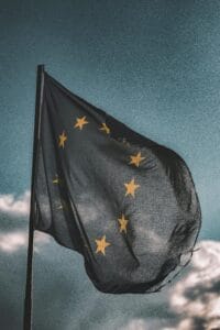 pexels-photo-1743364-1743364 European Union flag gently waving on a flagpole against a cloudy sky, symbolizing unity and patriotism.